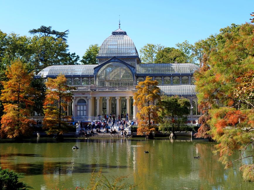 A large, historic red-brick building with a steep, gabled roof covered in red tiles, situated within a landscaped garden at Crystal Palace Park. The building features multiple small windows along its